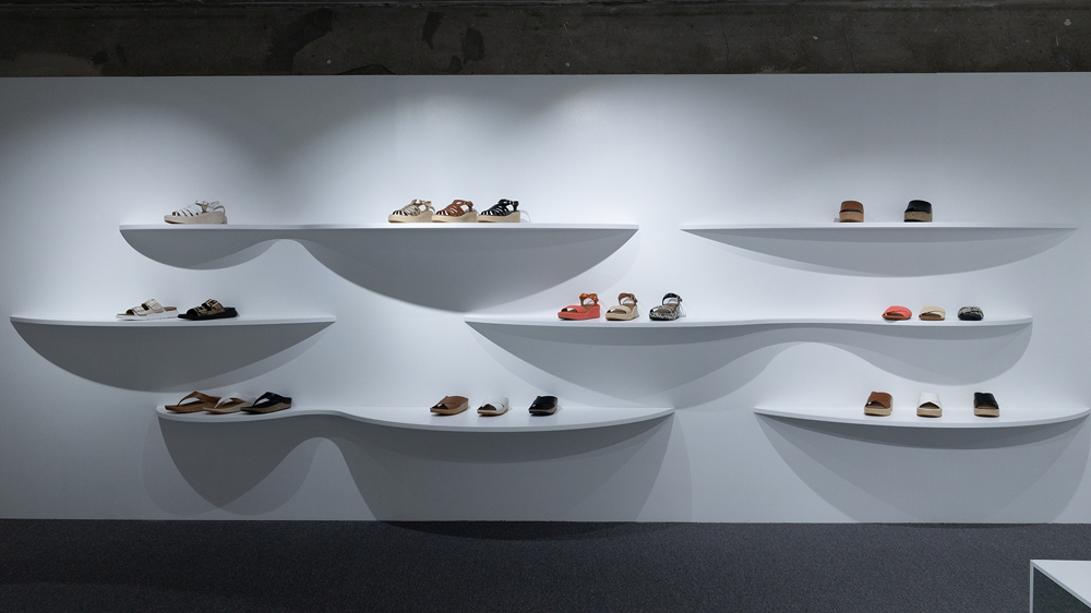 FitFlop sandals and slides displayed on curved white shelves inside the brand’s “0 STEP” pop-up store in Seongsu.