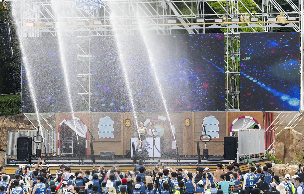 Water cannons spray over the crowd as the Water Music Pool Party brings music and water effects together at Caribbean Bay