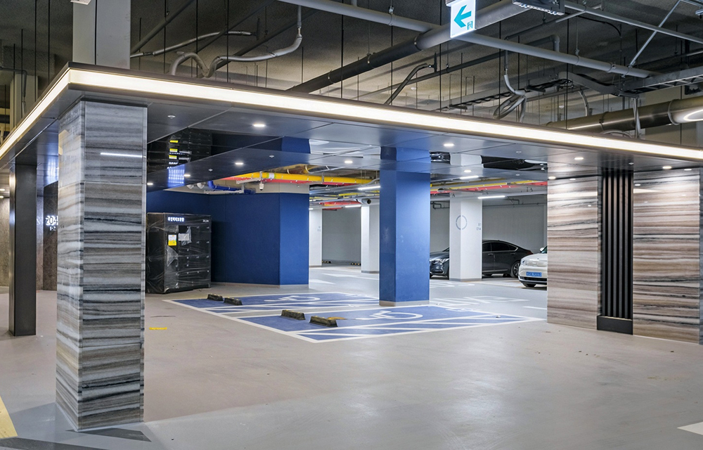 Raemian One Perla’s wide drop-off zone uses horizontal stone patterns and line lighting to create a refined arrival experience