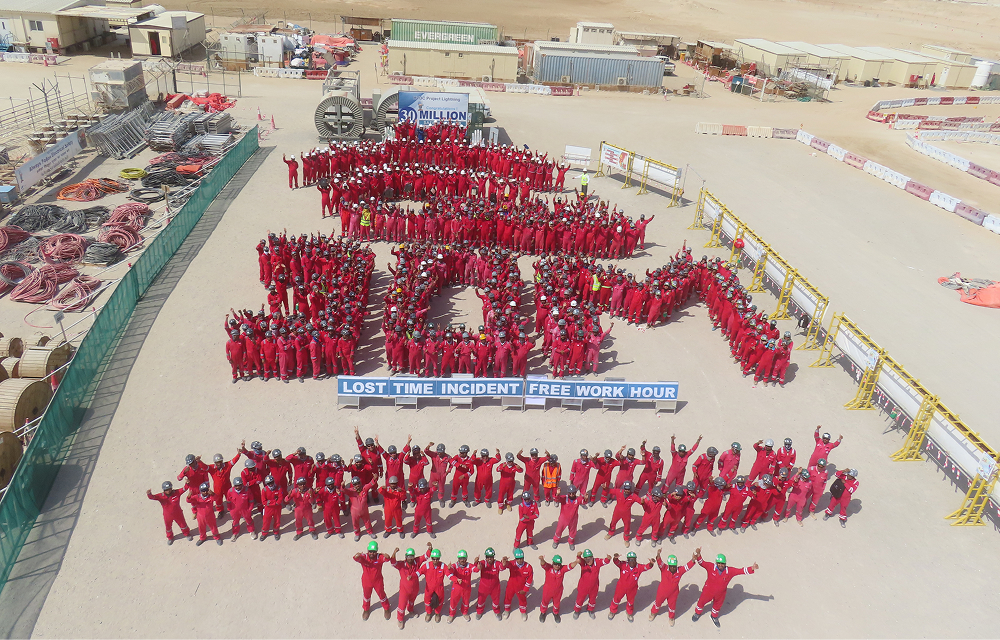 Aerial view of hundreds of UAE HVDC project employees in red protective clothing gathered at the construction site to celebrate 30 million work hours without a lost-time injury.