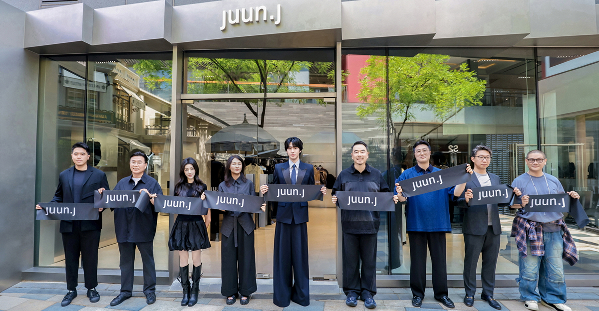 JUUN.J global ambassador Ahn Hyo Seop and eight representatives stand outside the new Beijing store holding black ribbons printed with the JUUN.J logo