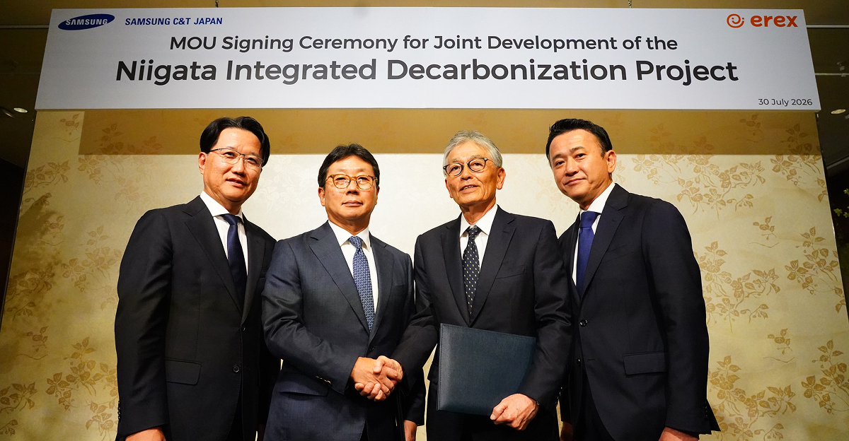 Four company representatives in suits stand together at an MOU signing ceremony for the Niigata Integrated Decarbonization Project, with two representatives shaking hands in front of a Samsung C&T Japan and eRex event banner.