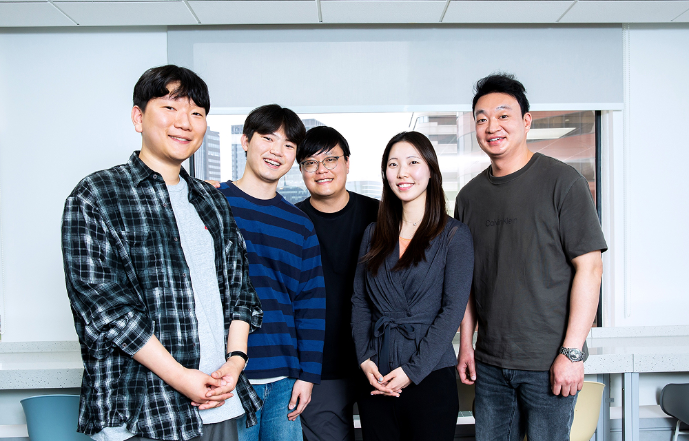 Five members of Samsung C&T’s Development 1 Group West Team stand together indoors in front of a large window.