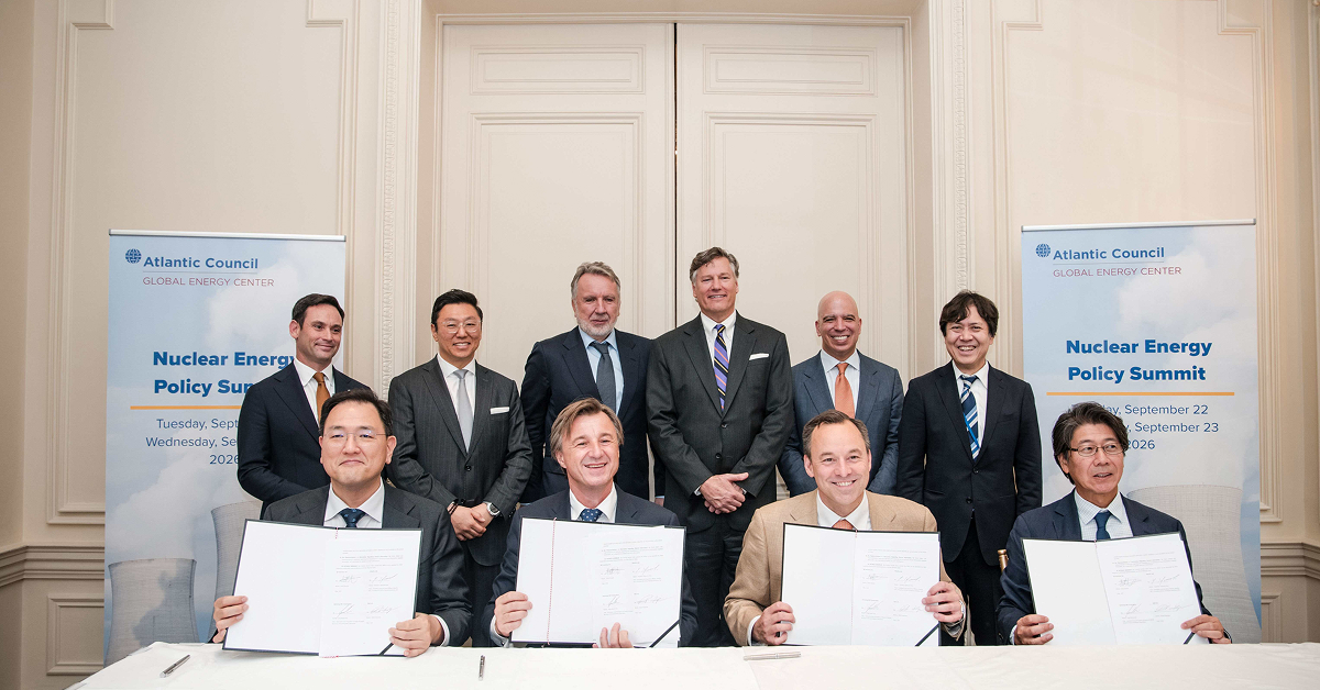 Four executives hold signed documents at the Atlantic Council Nuclear Energy Policy Summit in New York, with six representatives standing behind them. Seated from left are Jung Wook Kim of Samsung C&T, Rafał Kasprów of SGE, Scott Strazik of GE Vernova and Yasuhiro Takeuchi of Hitachi.